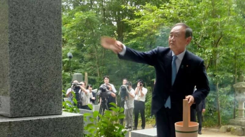योशीहिदे सुगा 2017 में इबाराकी प्रान्त में अपने गुरु सेरोकू काजियामा की कब्र पर श्रद्धांजलि अर्पित करते हैं