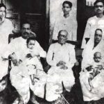 एसी भक्तिवेदांत स्वामी प्रभुपाद अपने परिवार के साथ (1924), बाएं से दाएं उनकी पत्नी राधारानी (खड़ी), स्वामी प्रभुपाद (पुत्र प्रयाग राज के साथ बैठे), उनके पिता गौर मोहन डे (बैठे), उनके भतीजे तुलसी (खड़े, पीछे गौर की मोहन डे), उनकी बहन राजेश्वरी अपनी बेटी सुलक्षमन (बैठे), उनके भाई कृष्ण चरण (खड़े) के साथ   
