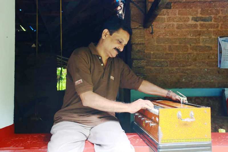 डॉ. राजिथ कुमार हारमोनियम बजाते हुए