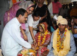 सामूहिक विवाह कार्यक्रम के दौरान पूजा करतीं साधना सिंह अपने पति के साथ