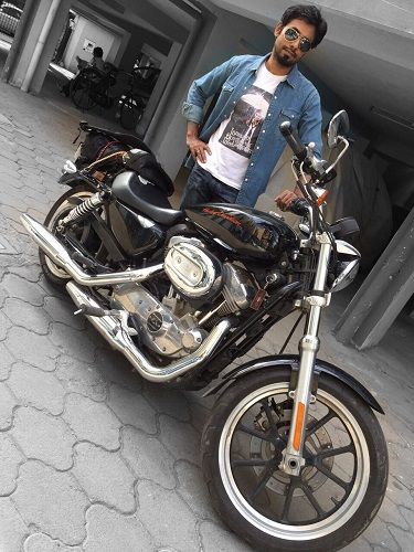 आरी अर्जुन अपनी मोटरसाइकिल के साथ