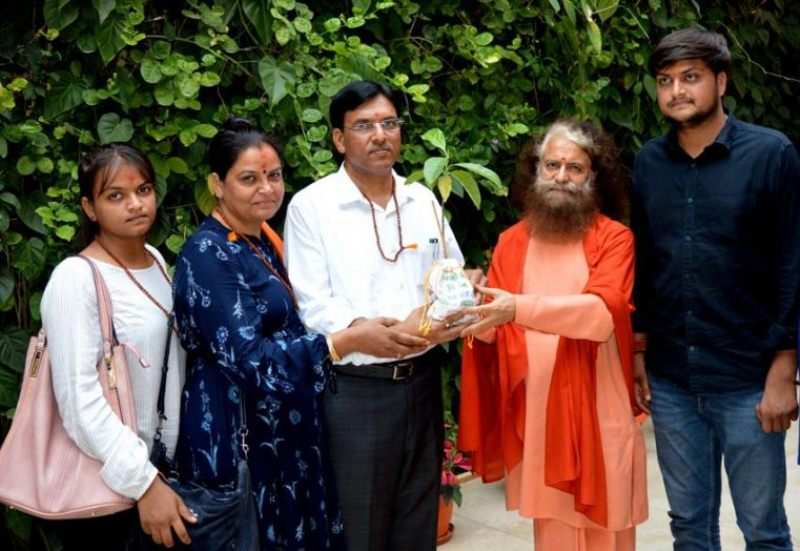 मनसुख मंडाविया और उनकी पत्नी और बच्चे एक हिंदू पुजारी के साथ
