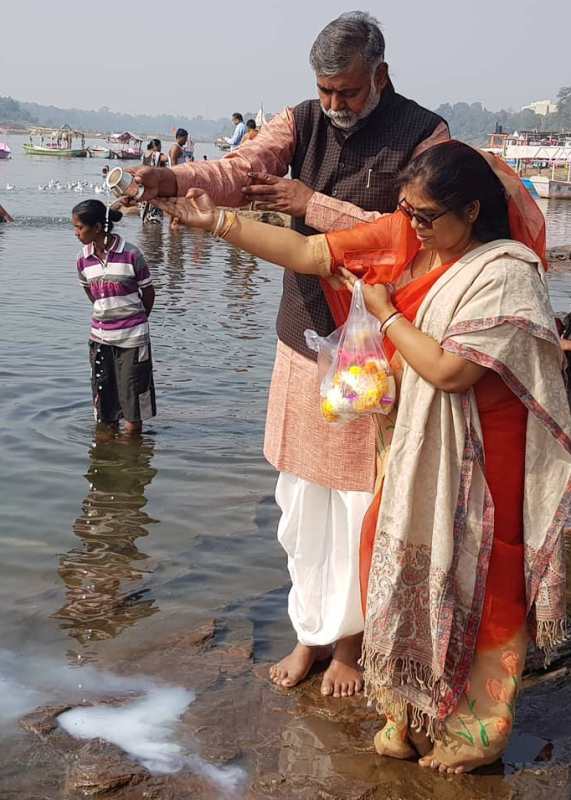 प्रह्लाद सिंह पटेल और उनकी पत्नी नर्मदा नदी में एक अनुष्ठान करते हैं