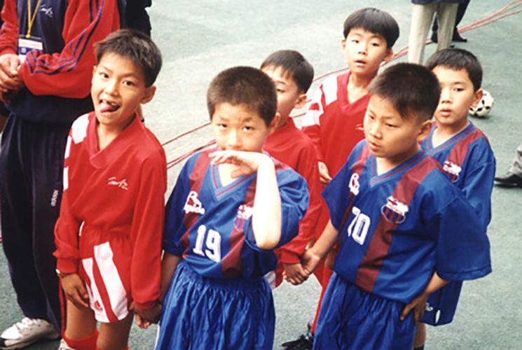 चा बम-कुन की फ़ुटबॉल कक्षाओं के अन्य फ़ुटबॉल खिलाड़ियों के साथ ली मिन-हो (नंबर 19 जर्सी वाला शर्मीला लड़का)